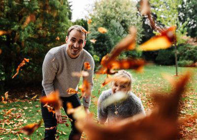 Autumn photoshoot dad and daughter throwing leaves