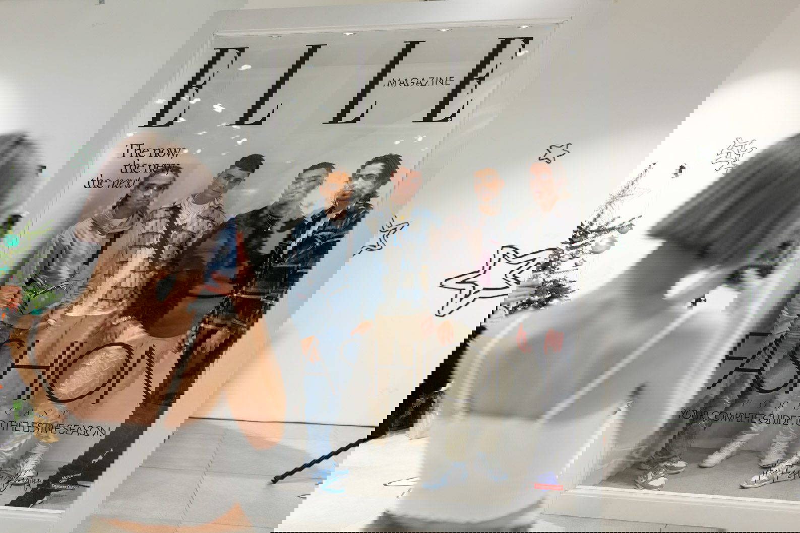 Guests posing inside a life-size magazine installation at a fashion brand activation