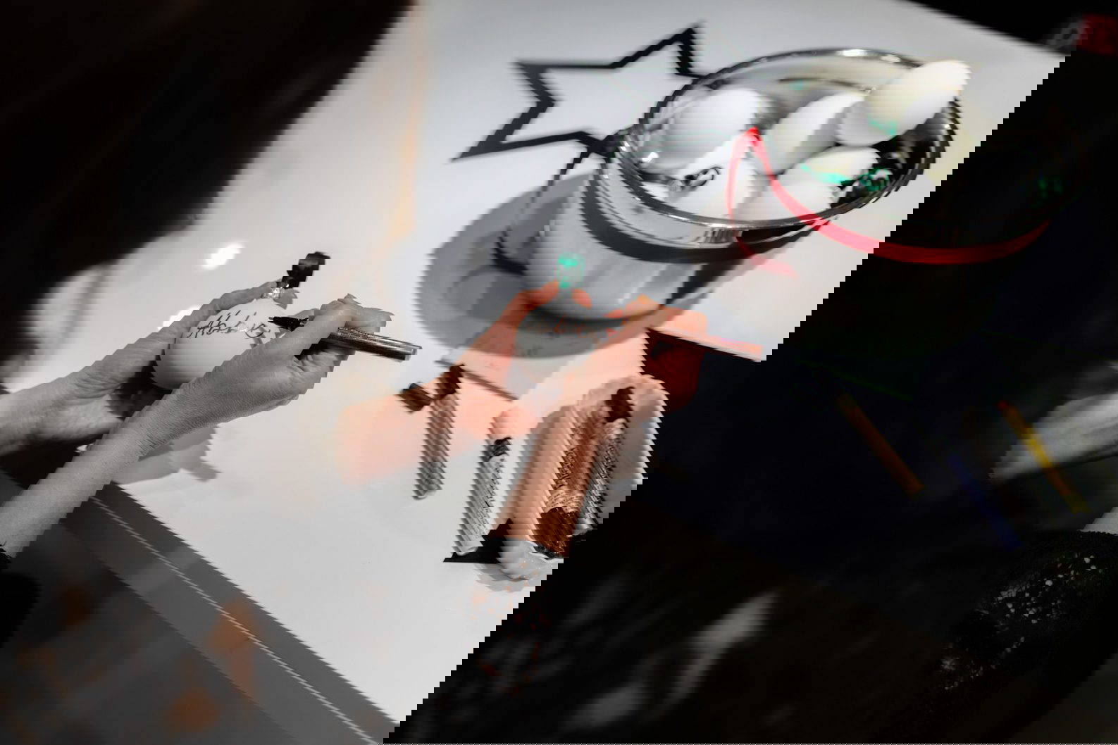 Live calligraphy writing guest names onto baubles at a brand activation