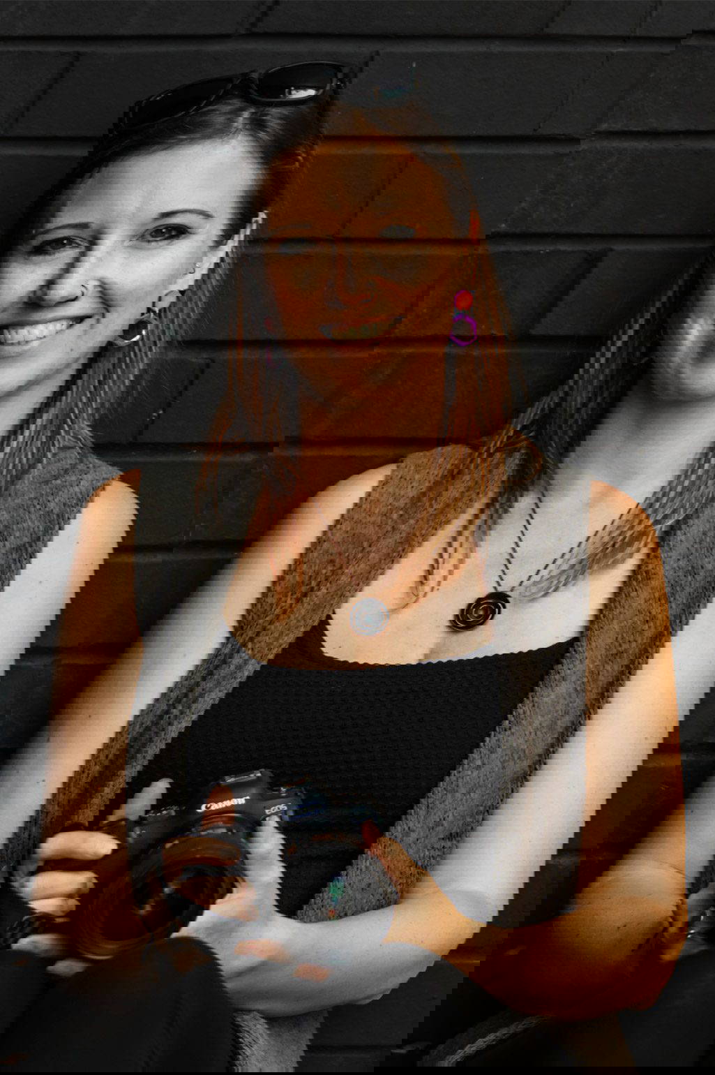 Amy Takes Photos holding a camera and smiling