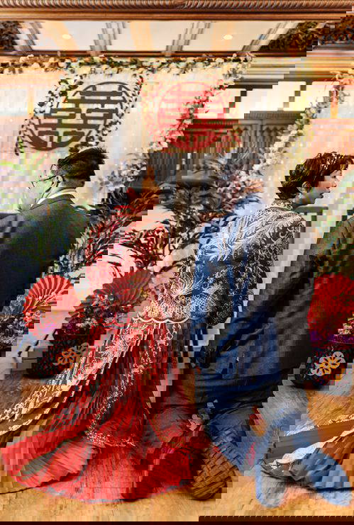 A moment of tradition at Pendrell Hall Couple taking part in a traditional tea ceremony during their wedding