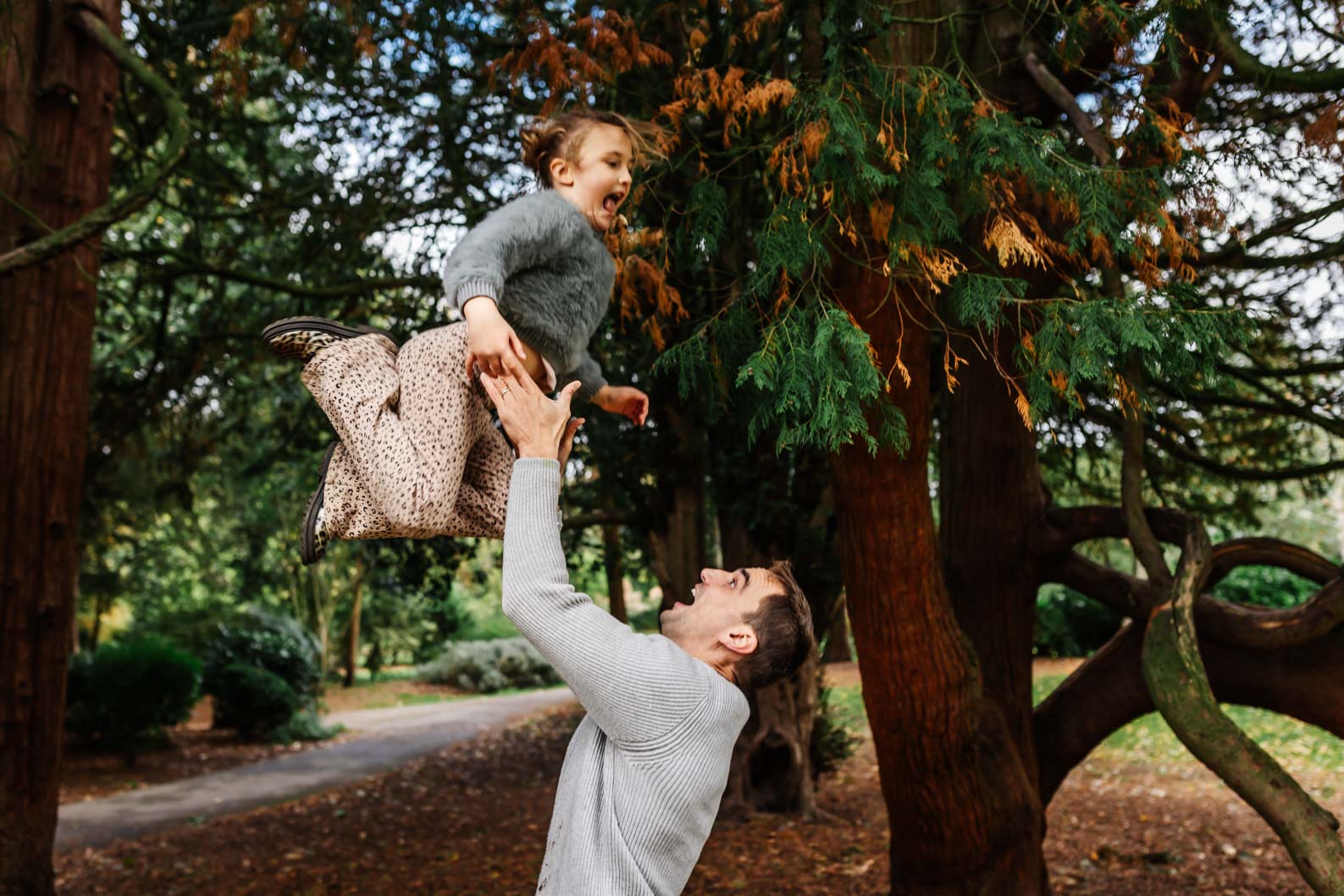 Dad lifting daughter in the air during a joyful family photoshoot Birmingham