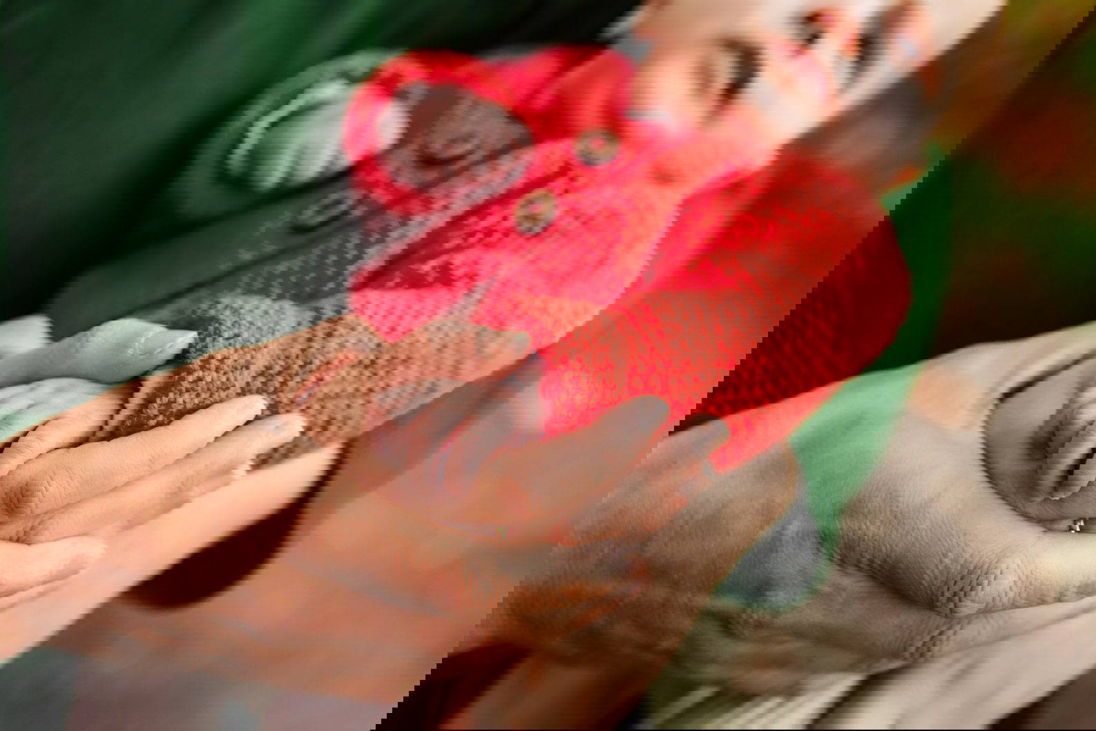 Close-up of parents holding baby’s hand during a family photoshoot in Birmingham”