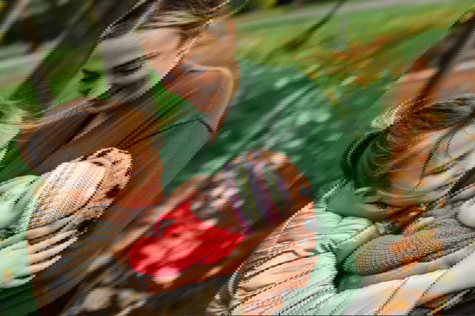 Mum and daughter cuddling baby during a natural family photoshoot in Birmingham
