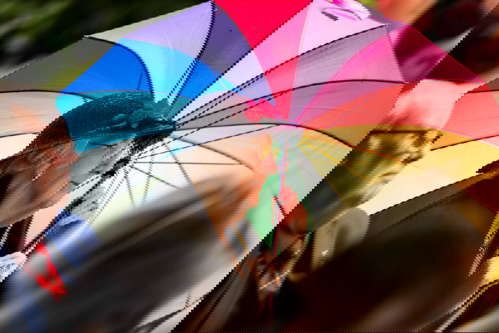 Wedding guest sheltering under umbrella during wedding ceremony