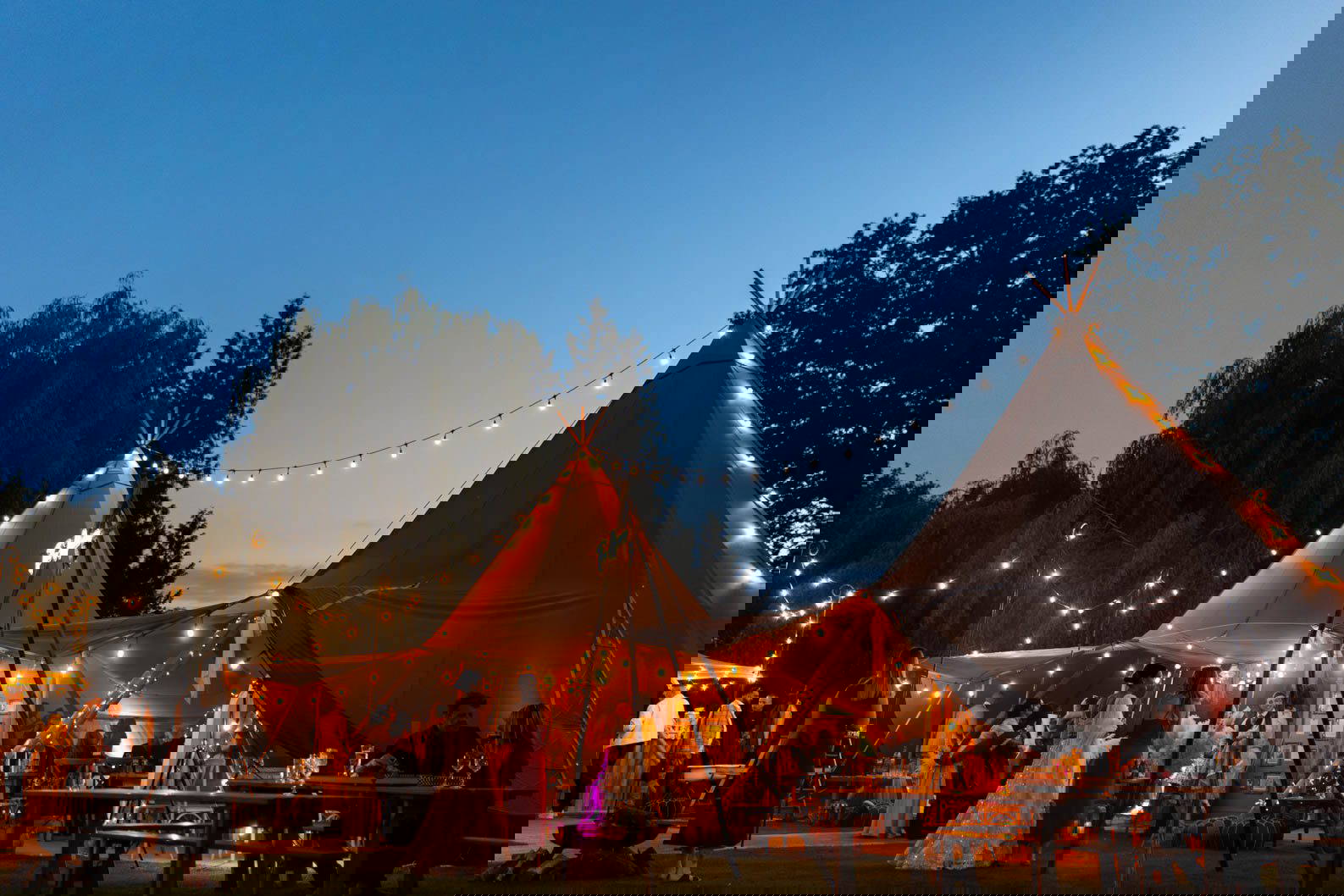 Beautifully lit wedding tipi as the sun sets