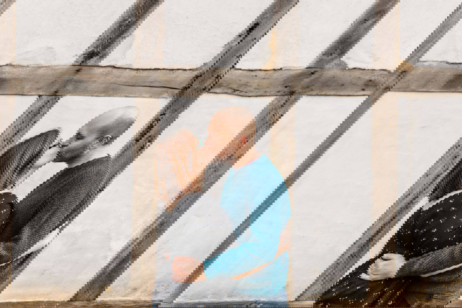 Couple kissing in front of historic buildings at Avoncroft Museum during their engagement shoot.