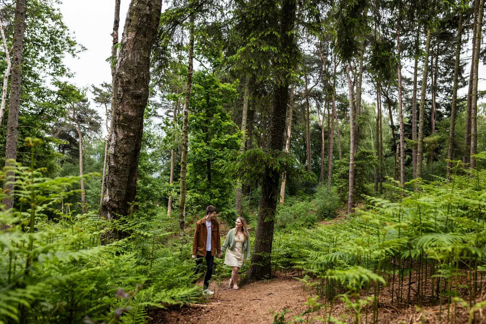 Couple walking hand in hand at Lickey Hills during golden hour on their pre-wedding shoot.