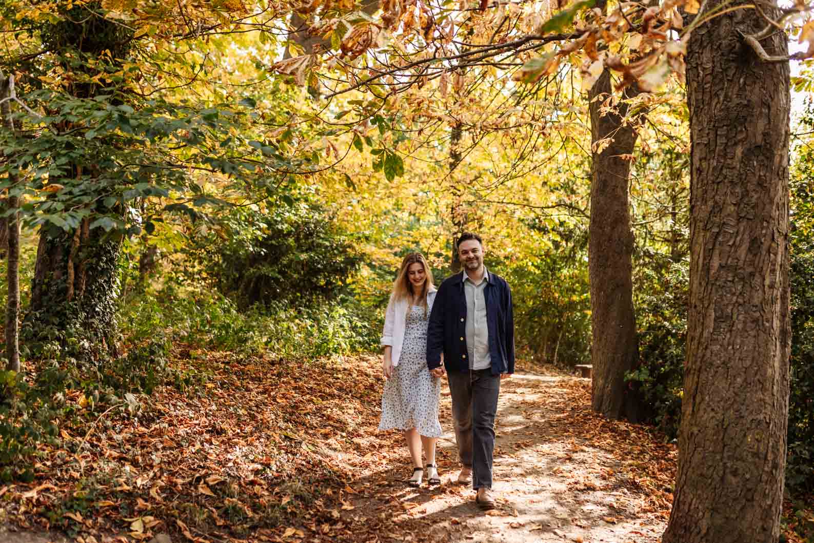 A relaxed pre-wedding shoot at Leasowes Park, capturing the couple wandering through the trees hand in hand