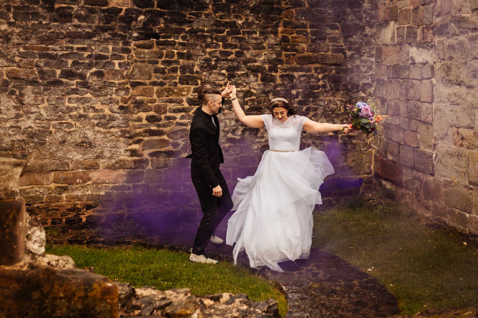 Bride and groom celebrating their wedding with smoke bombs at the ruins near Dudley Register Office, photographed candidly and beautifully.