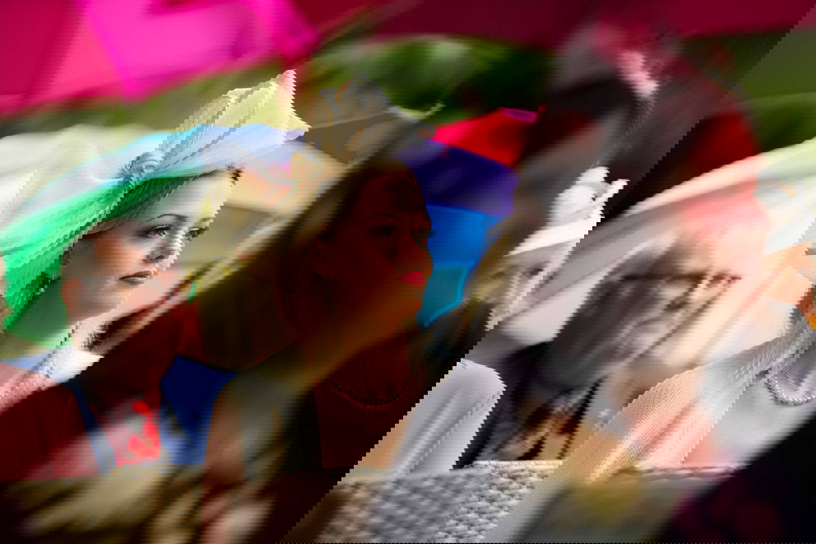 Wedding guest sitting among colourful umbrellas in the rain at Moxhull Hall, West Midlands