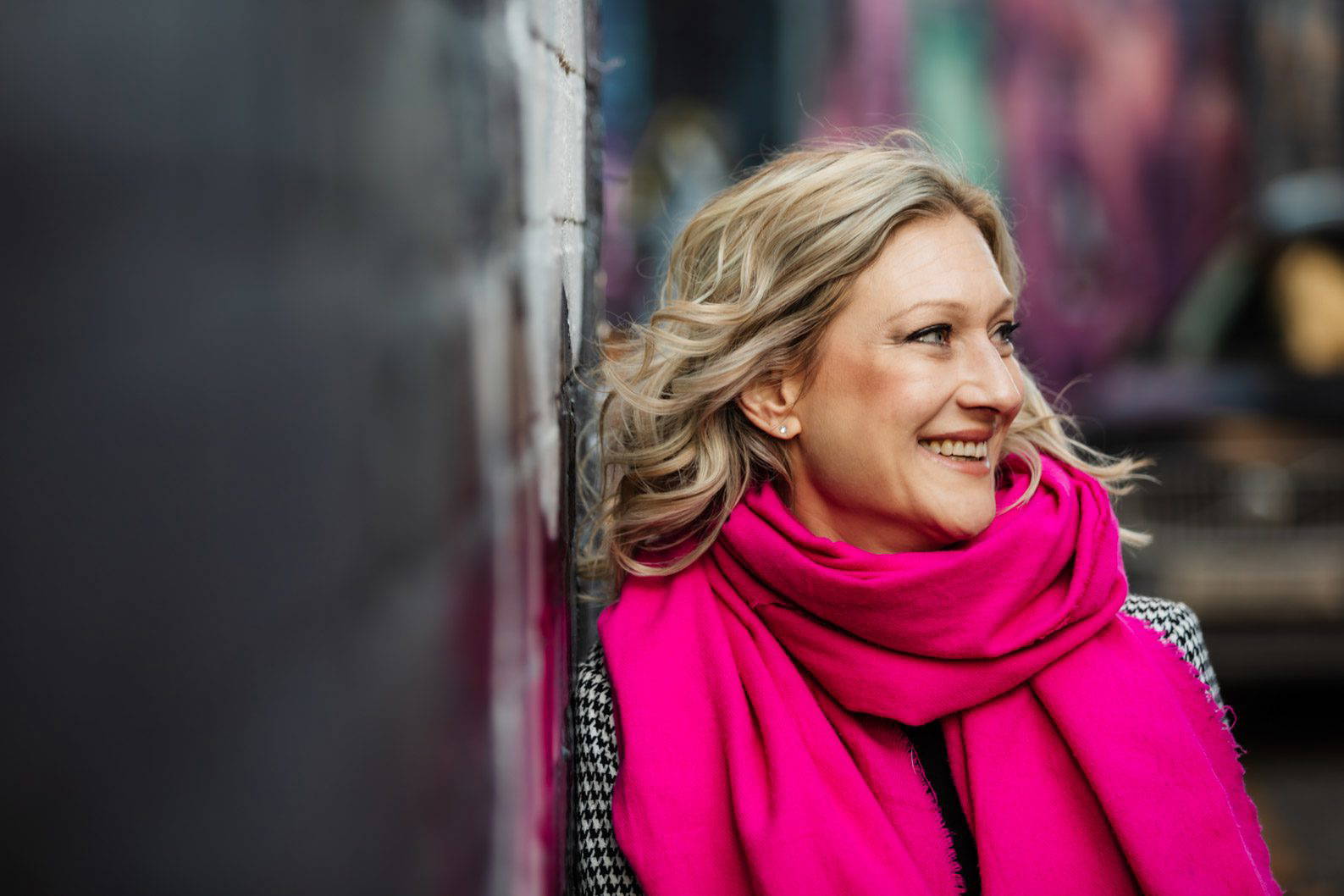 Natural headshot taken in Digbeth, Birmingham showing relaxed expression with industrial creative background.